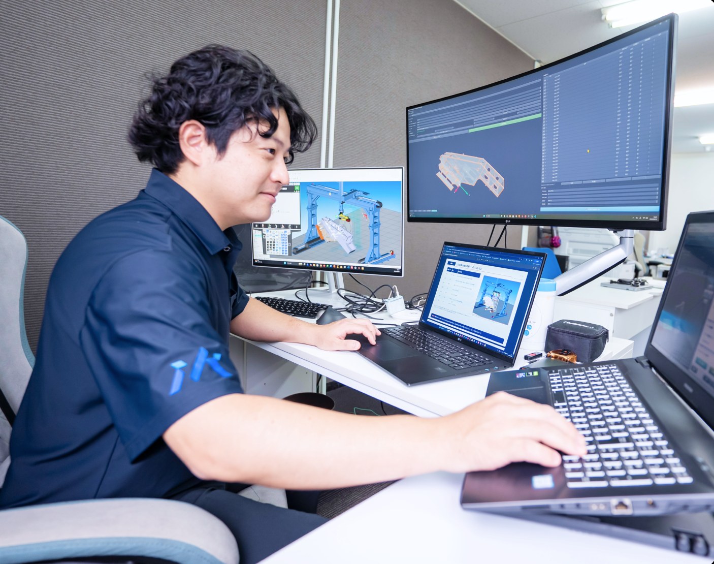 デスクでロボットの動作をシミュレーションするエンジニア