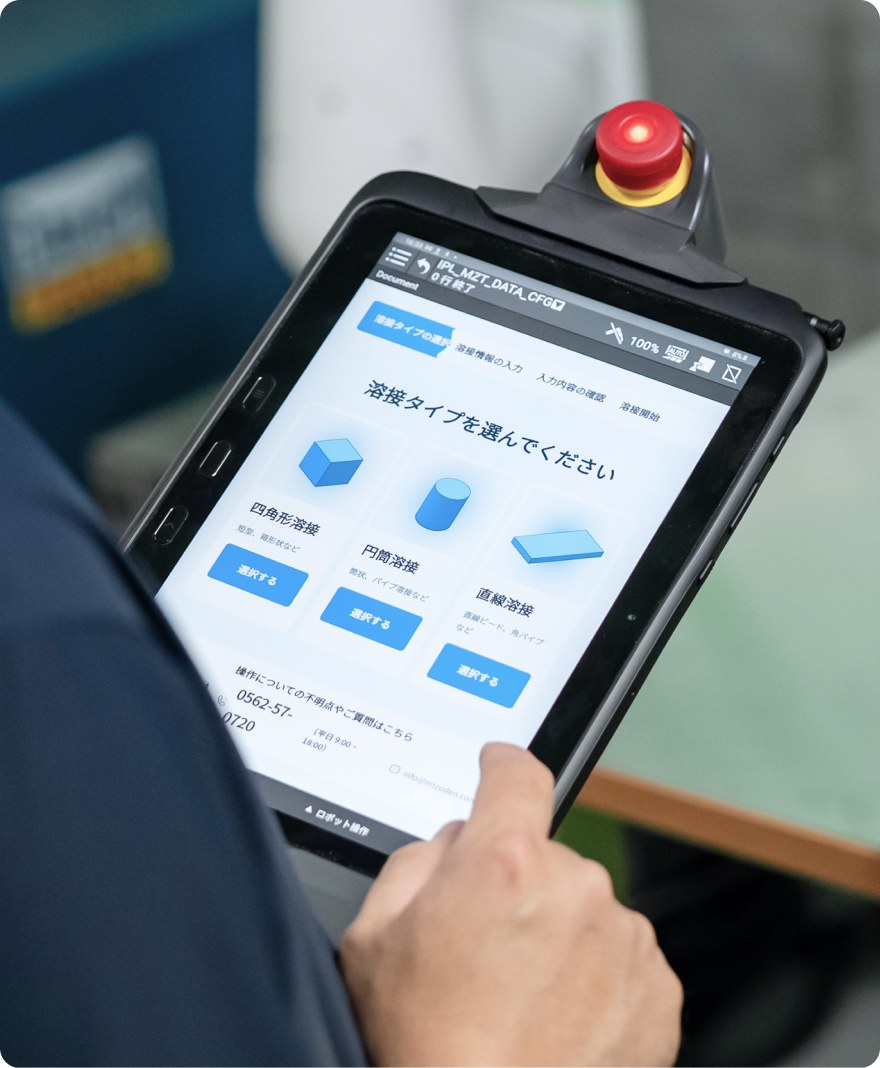 タブレットで溶接ロボットを操作する様子